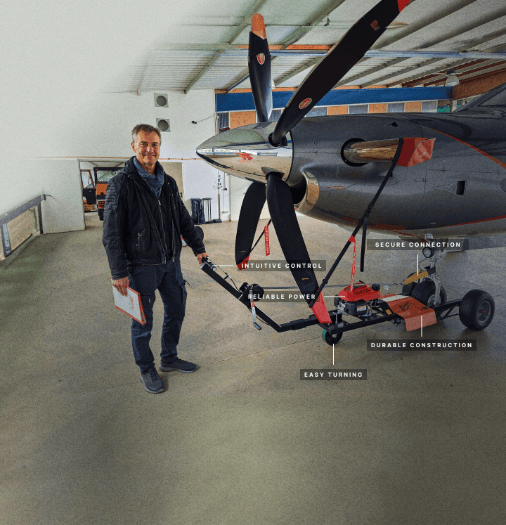 man standing by aircraft tug with labeling