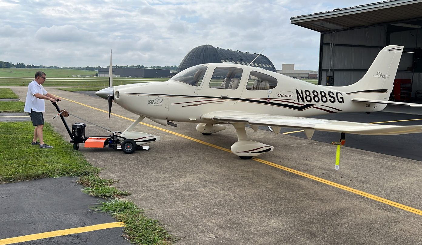 airtug pulling an aircraft outside of a hanger