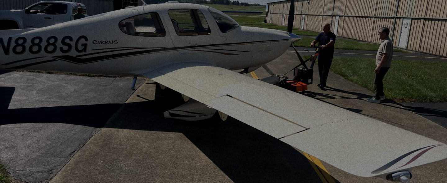 two men maneuvering aircraft with an airplane tug